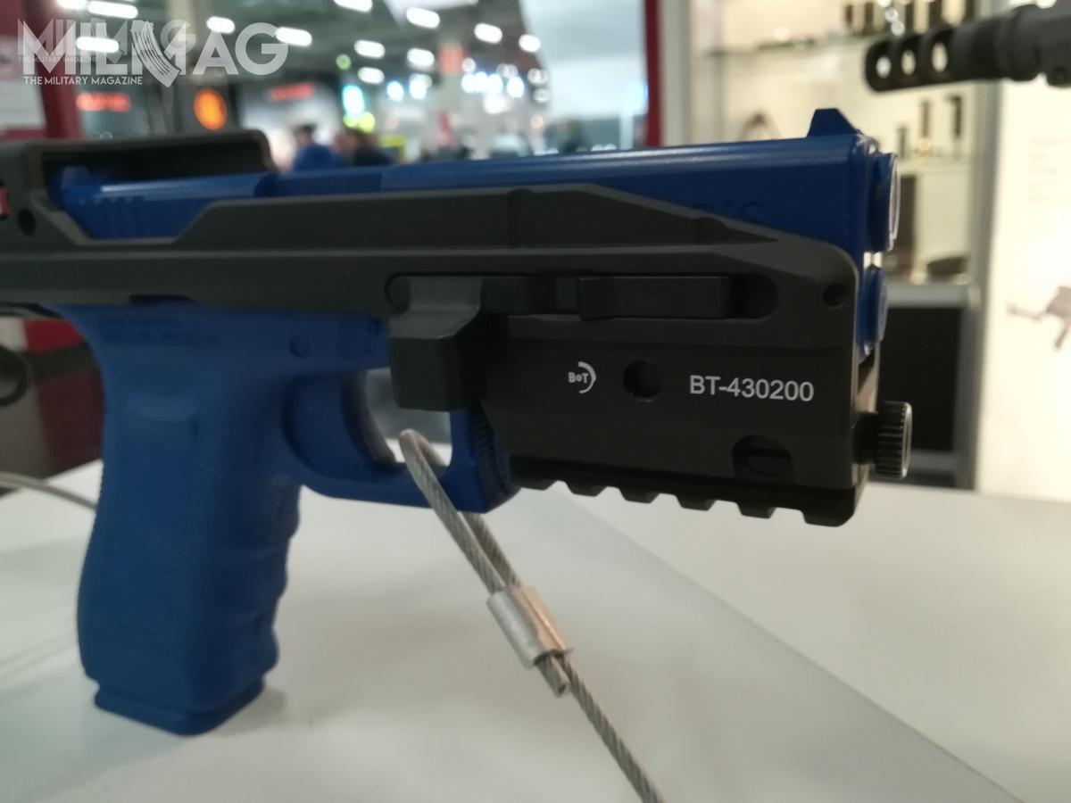 Widoczny zatrzask kolby w położeniu zamkniętym i szyna Picatinny dla chwytu przedniego lub latarki.